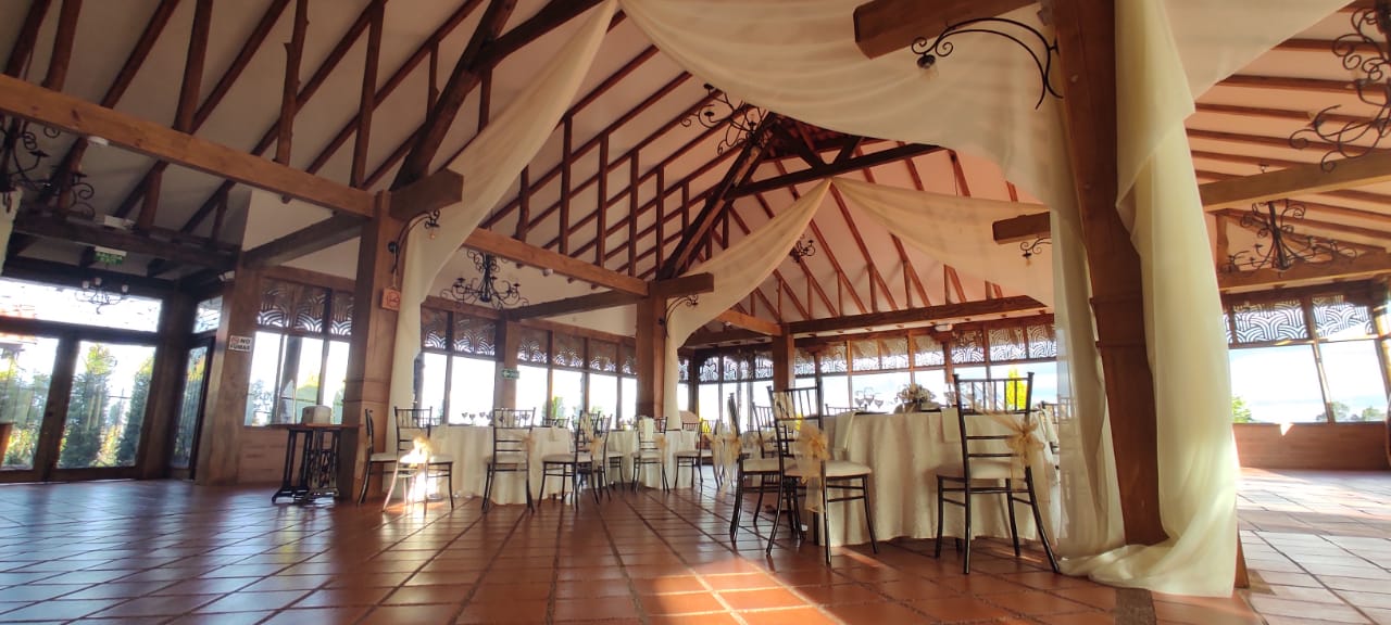 Salón principal de Quinta Margarita con techo de vigas de madera y mesas preparadas